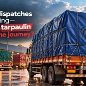 Export Quality Tarpaulin Manufacturer showcasing a large cargo truck covered with a blue tarpaulin secured by ropes, with other transport vehicles outside a warehouse on wet pavement during festive dispatches