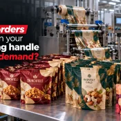 Laminated Packaging Manufacturer showcasing printed pouches for namkeen, dry fruits, and chocolates arranged beside packaging film running through machinery in a manufacturing facility