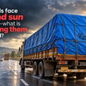 Large cargo truck travelling on a wet highway with its load covered by a blue tarpaulin secured with ropes, illustrating transport protection when comparing the Best Tarpaulin Brand in India